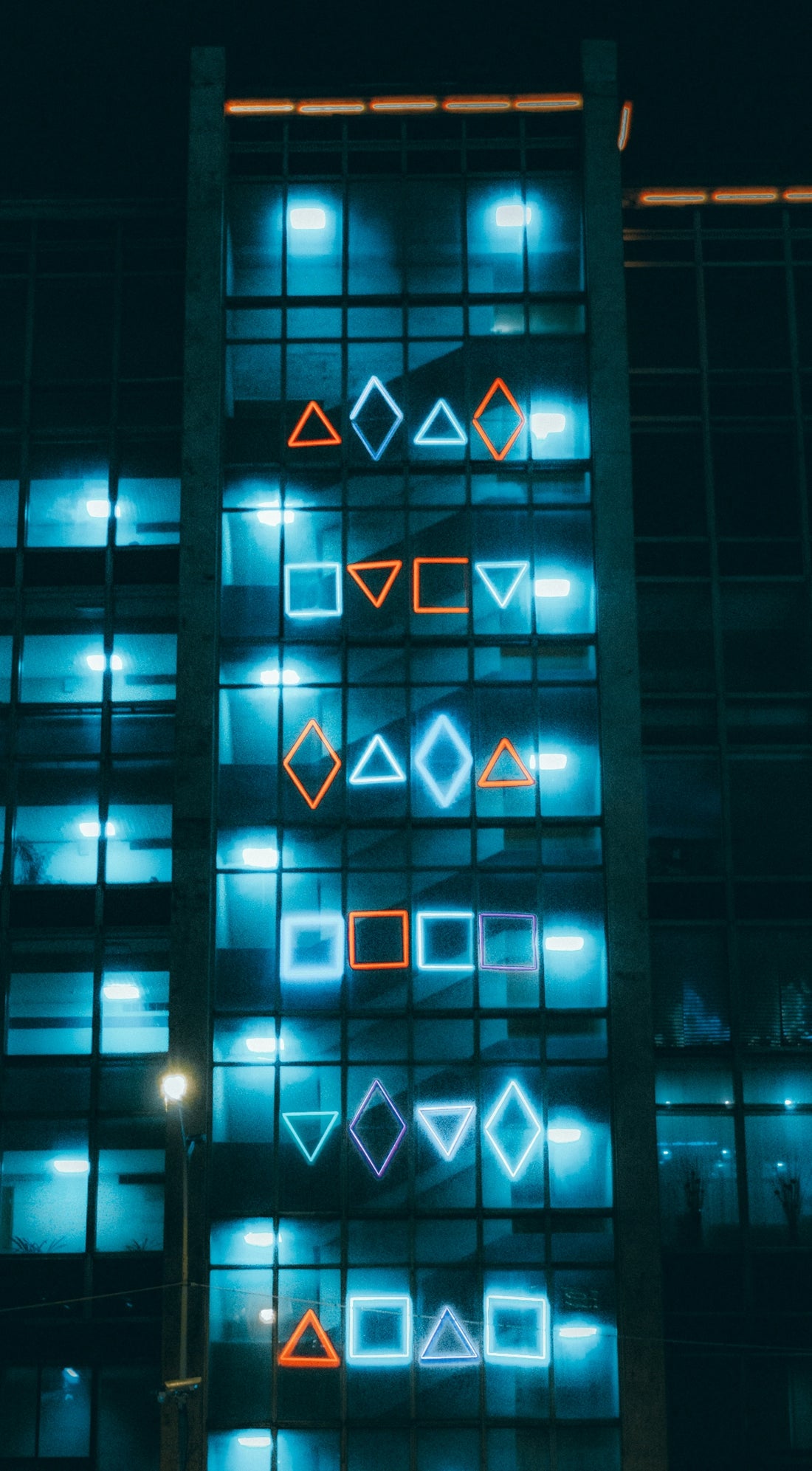 blue and black building with lights turned on during night time