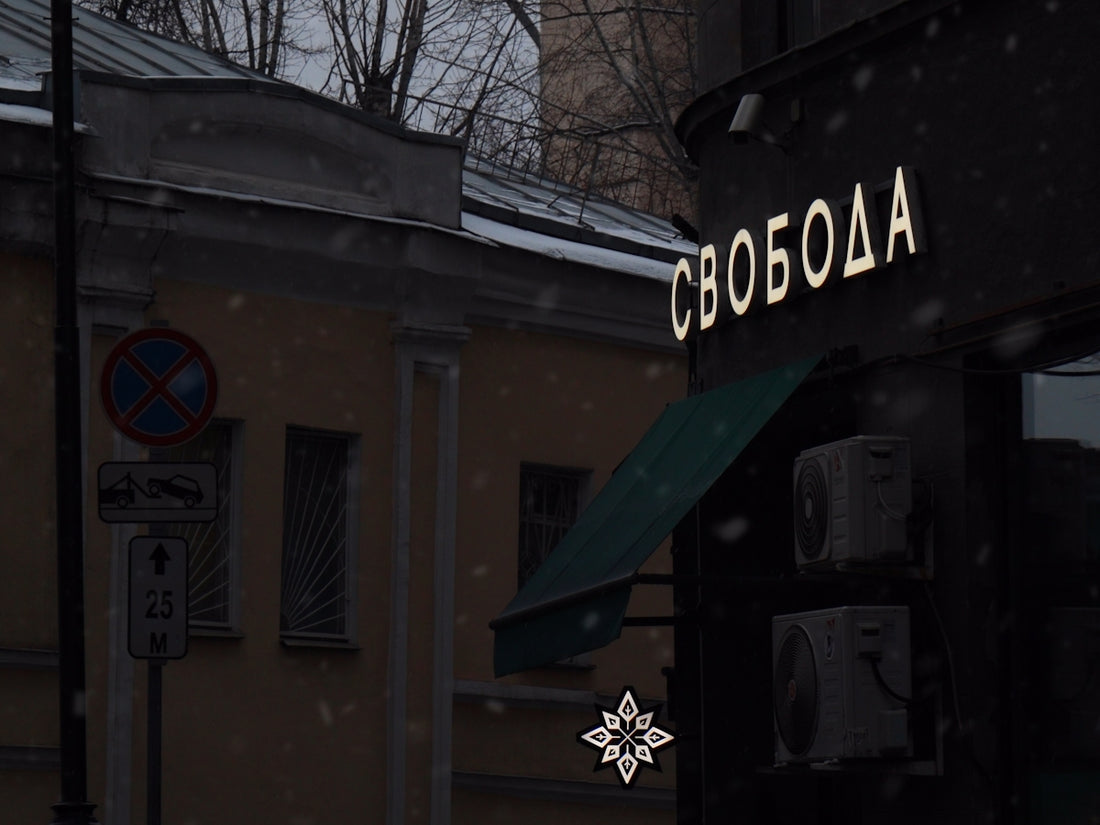 a building with a green awning next to a snow covered street