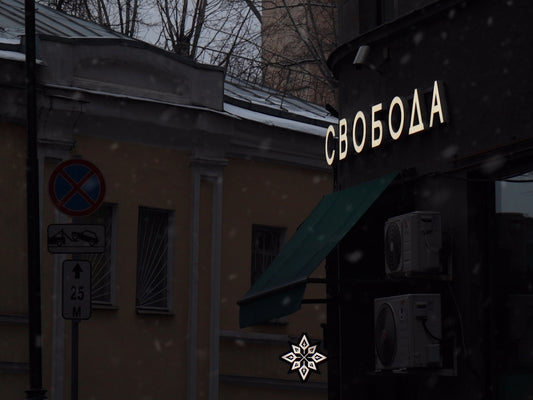 a building with a green awning next to a snow covered street