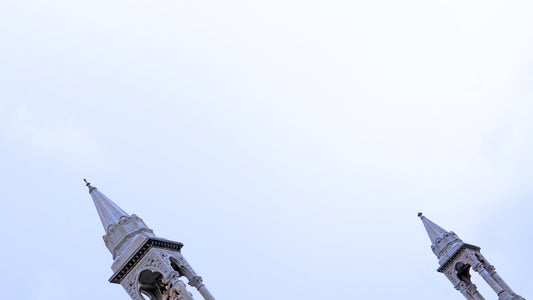 two spires of a building against a blue sky