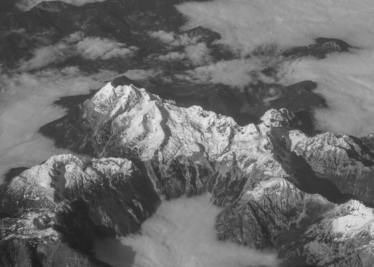 a black and white photo of snow covered mountains