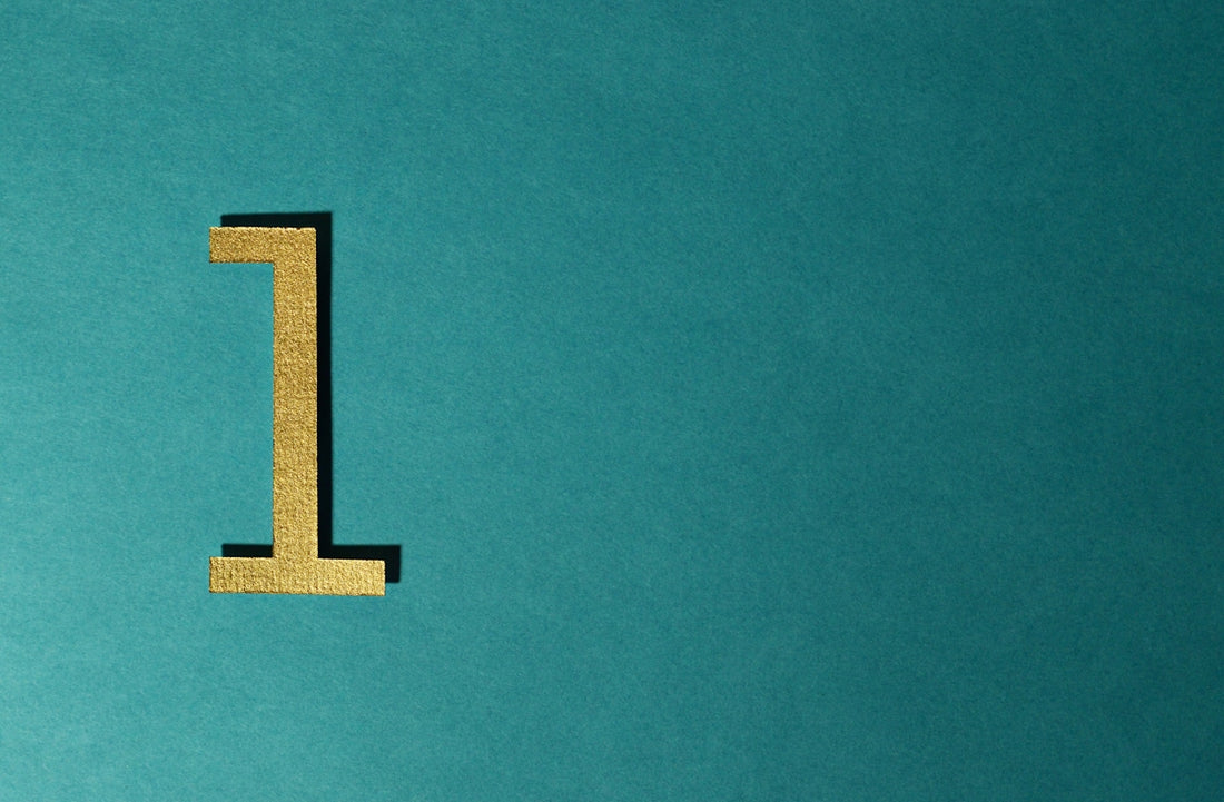 A gold number one is on a blue surface.