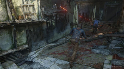 Scene from Uncharted: Legacy of Thieves Collection showing characters escaping a ruined building with lasers.